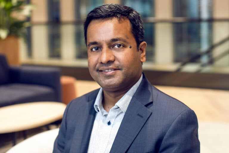 Portrait of a man in a suit smiling indoors