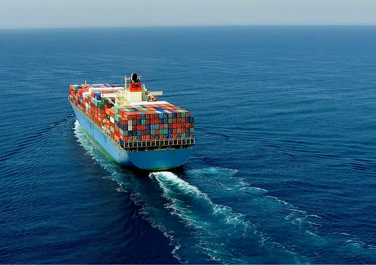 Cargo ship carrying colorful shipping containers sailing on the ocean