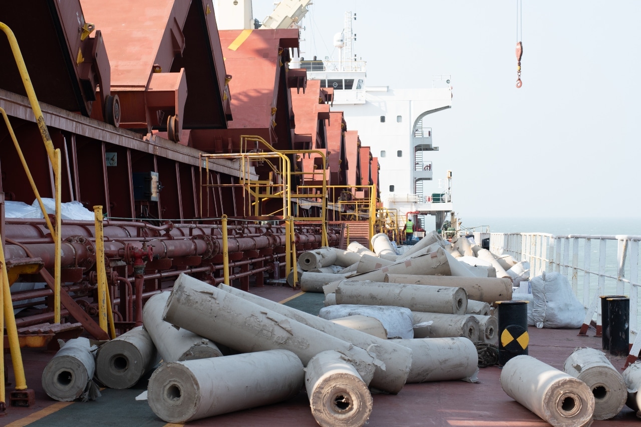 Large cargo ship deck with rolled industrial materials ready for shipment